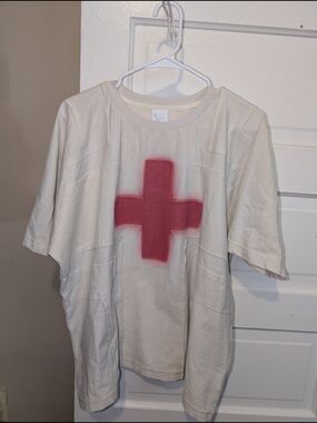 BAD SON "Healer Tee" in a beige/off-white color red cross graphic